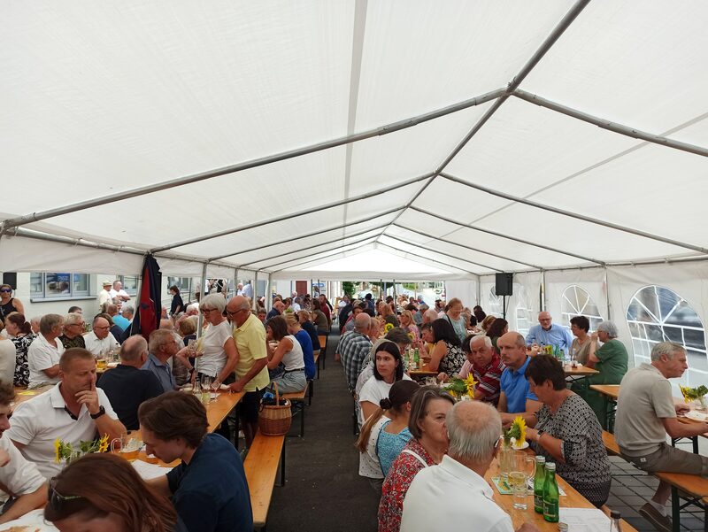 Gäste beim Mittagessen an den Tischen im Festzelt